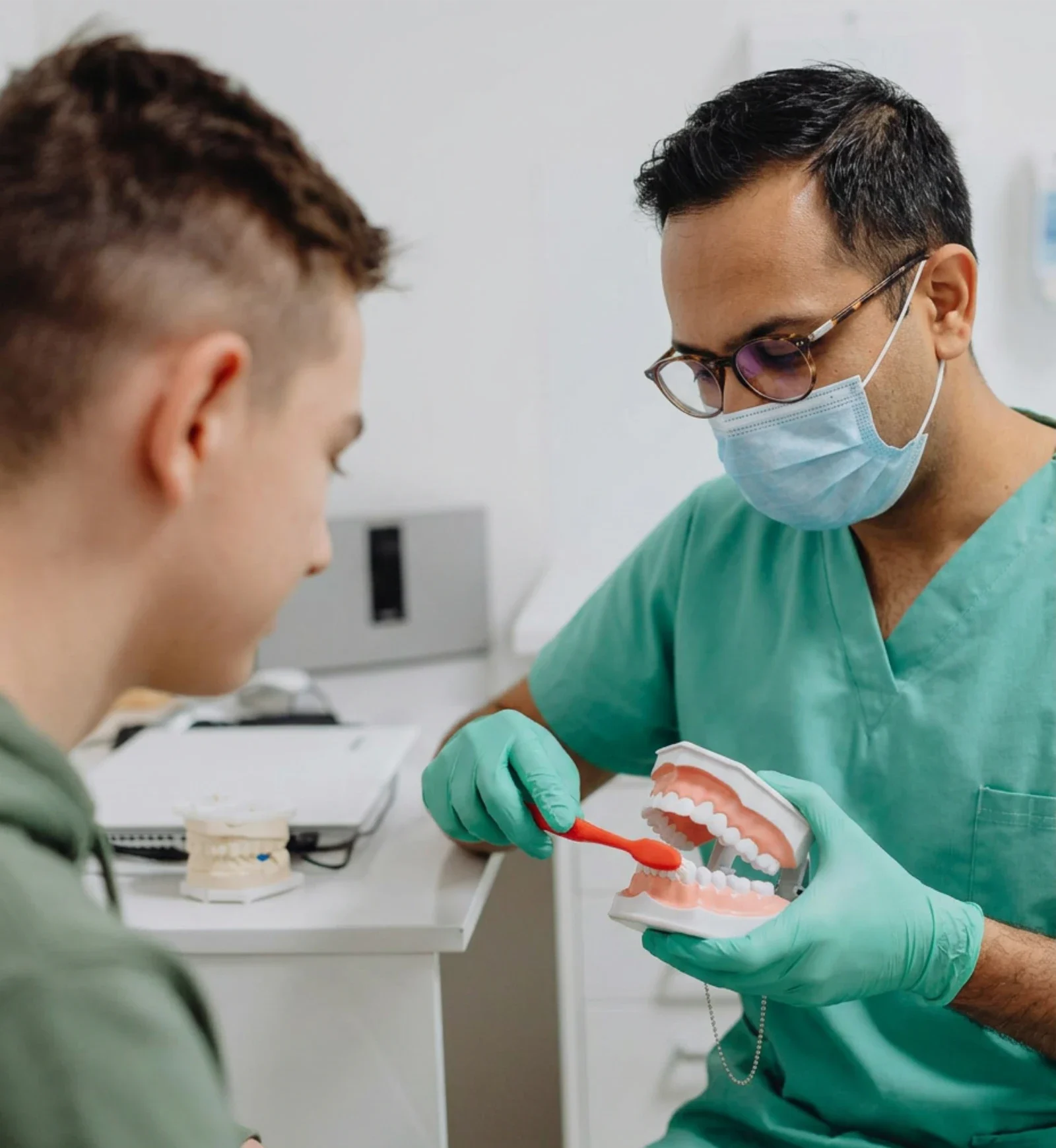 Dr. Kalucha showing a young patient how to brush at Mount Lehman Dental